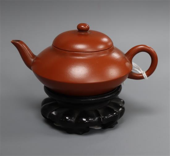 An inscribed Yixing teapot, late 19th/early 20th century, 10.2cm across, wood stand, small chip to spout